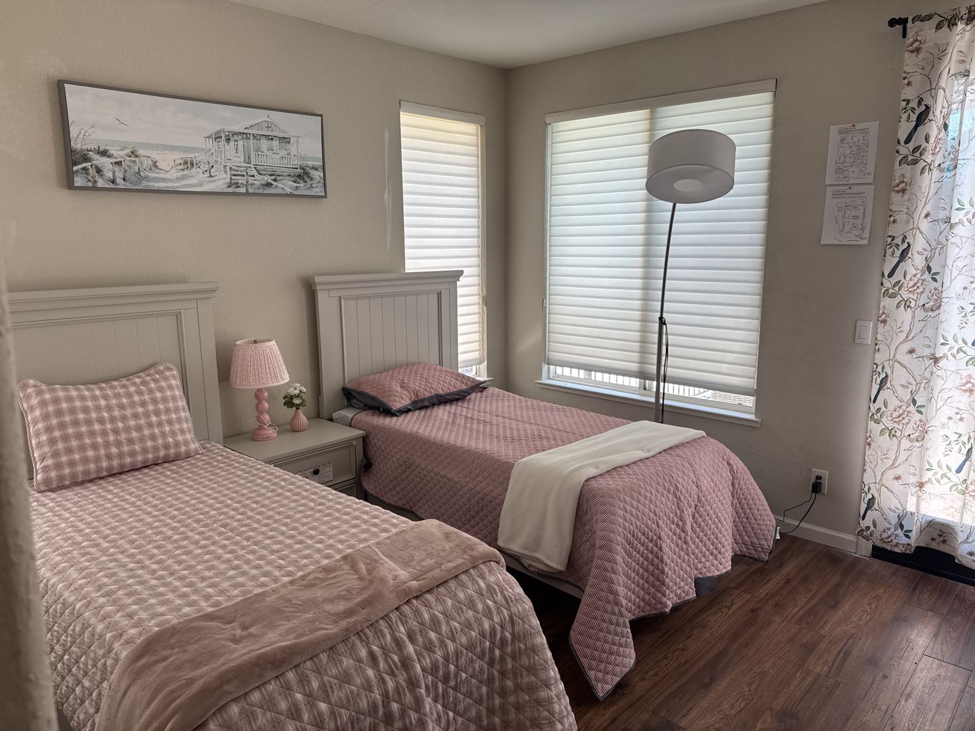 Companion room with two neatly made beds, soft lighting, and coastal artwork.